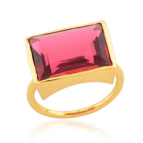 A gold band ring with a rectangular ruby red crystal in the centre.