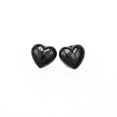 A pair of small black glass heart stud earrings.