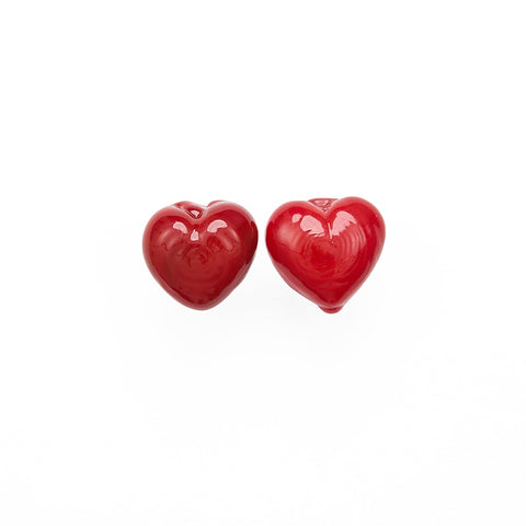 A pair of small red glass heart stud earrings.