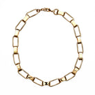 Chunky gold chain necklace against white background.