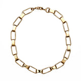 Chunky gold chain necklace against white background.
