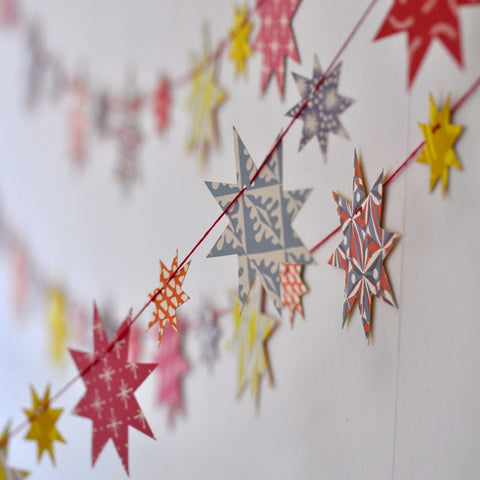 Multicoloured stars on a garland hanging in a room. 