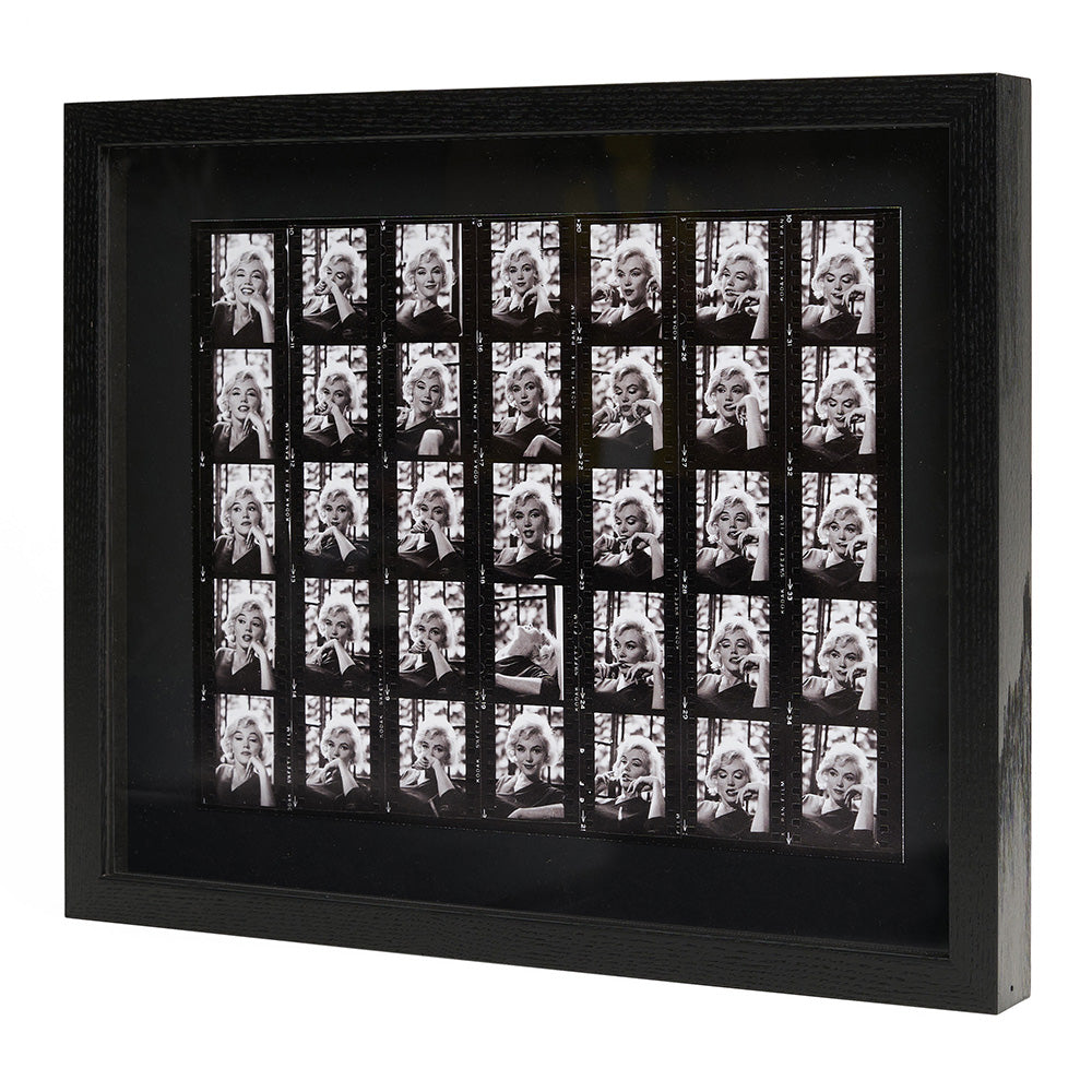 Side view of black and white contact sheet photographic print in a black frame.