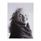 A magnet with a black and white photograph of a woman smiling against a white background.