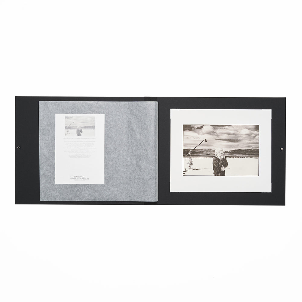 Open black folio with back and white photographic print and certificate on a white background
