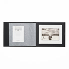 Open black folio with back and white photographic print and certificate on a white background