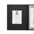 Open folio with black cover and certificate of authenticity.