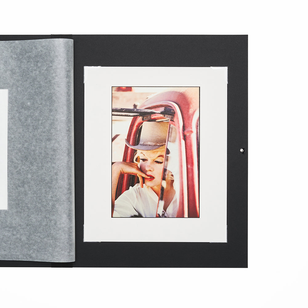 Close up view of open folio with a black cover displaying a photo of a woman in a car.