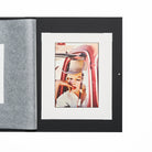 Close up view of open folio with a black cover displaying a photo of a woman in a car.