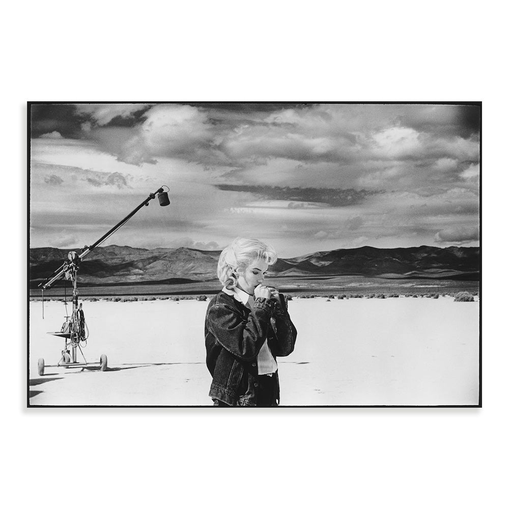 Black and white photograph of a person with a microphone against a scenic background