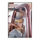 Colour photograph of a person wearing a hat, looking out of a pink vehicle window