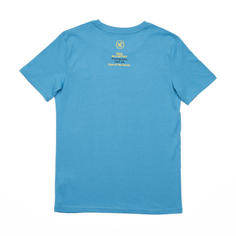 Reverse of the blue T-shirt featuring the exhibition title 'Paul McCartney Photographs 1963-64' and the National Portrait Gallery logo.
