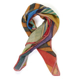 A stripe patterned silk scarf in orange tones folded and styled.