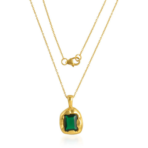 A thin gold chain necklace with a gold encased green crystal stone pendant.