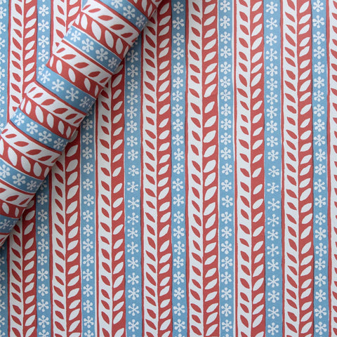 Red, white and blue striped wrapping paper with leaves and snowflakes decorating each stripe. 