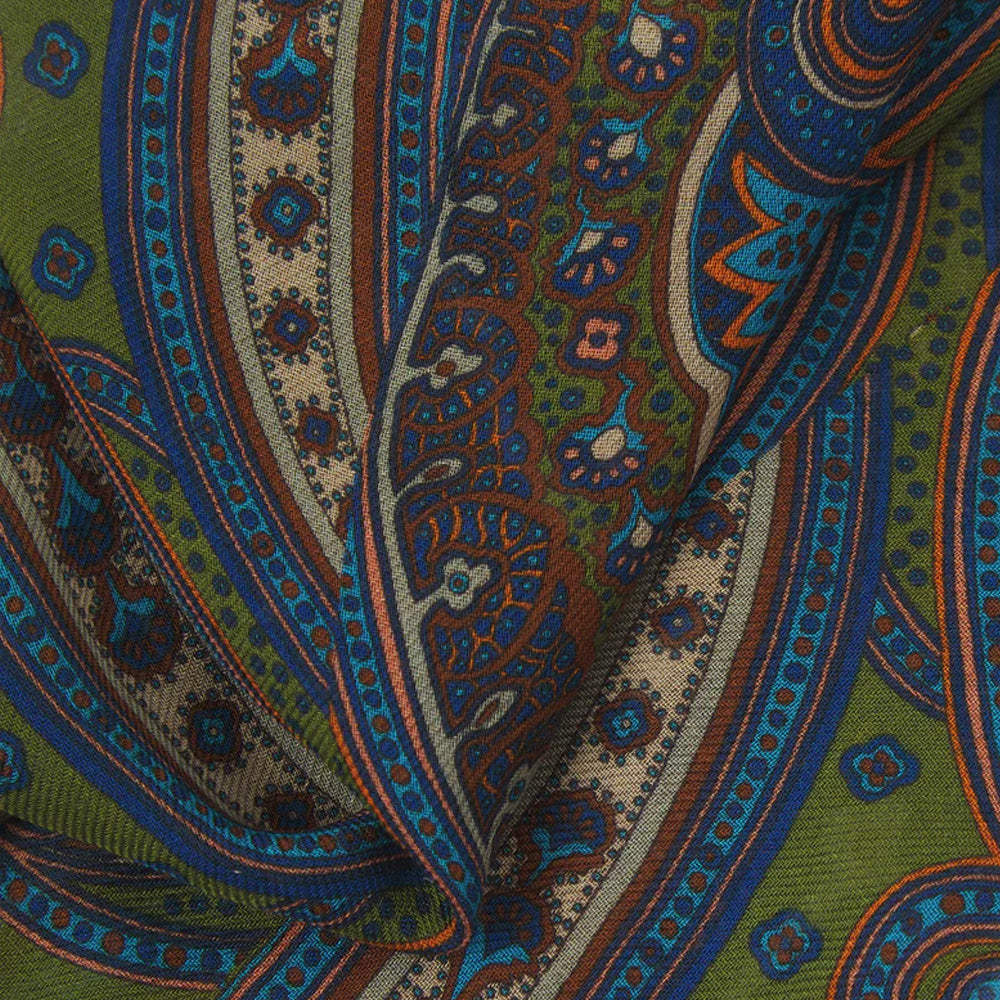 Close up of a patterned fabric with intricate designs in green, blue, and brown.