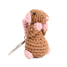 Side view of crocheted rat keychain with pink ears and feet, with black beaded eyes, on a white background