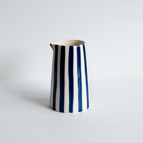 Tall ceramic jug with painted blue vertical stripes.