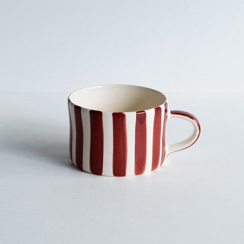 Wide ceramic mug with handles and paprika red painted vertical stripes.