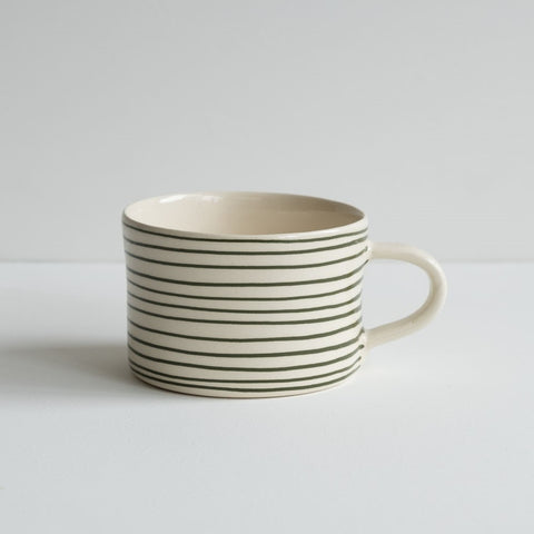 A low wide mug featuring thin painted moss green stripes.