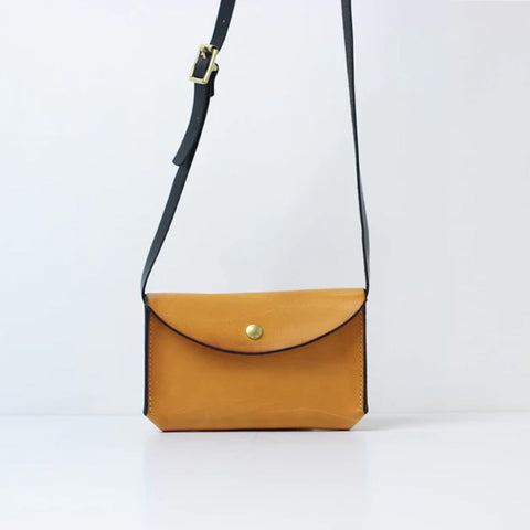 Small rectangular leather bag in yellow with contrasting black strap and gold popper closure.