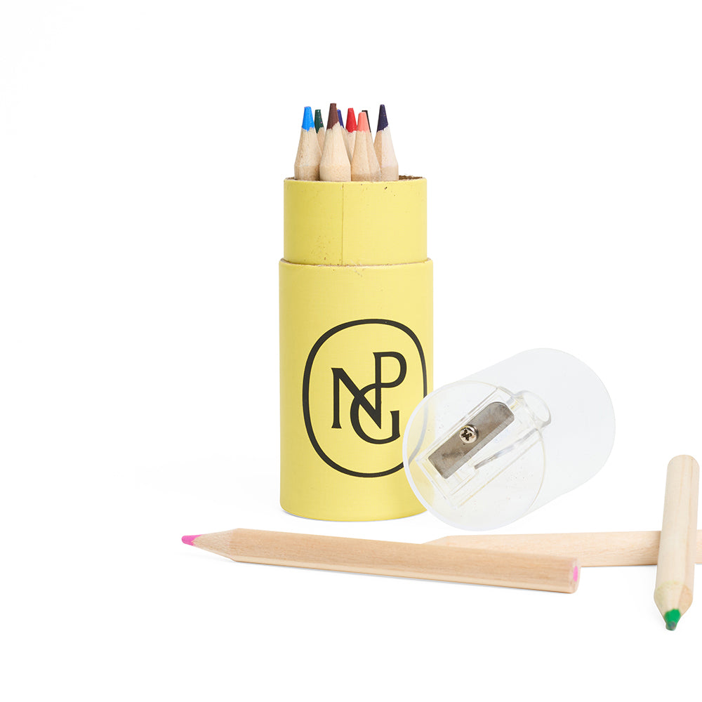 Yellow tube container with coloured pencils and a sharpener on a white background