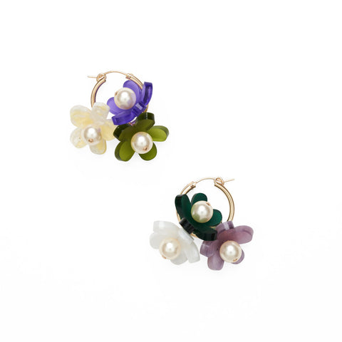 A pair of gold hoop earrings each with three hanging 3D flower charms.