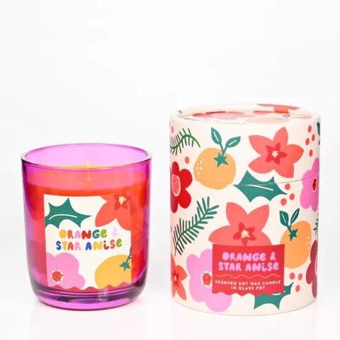 Pink glass candle with its colourful, cylindrical, floral packaging.