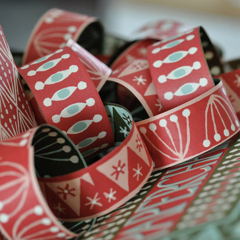 A red and white decorated paper chain decoration in a pile. 