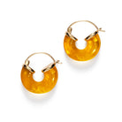 A pair of circular amber resin earrings on gold hoops