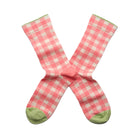 Pink and white checkered socks with green accents on a white background