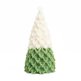 Snow covered green pine tree candle. 