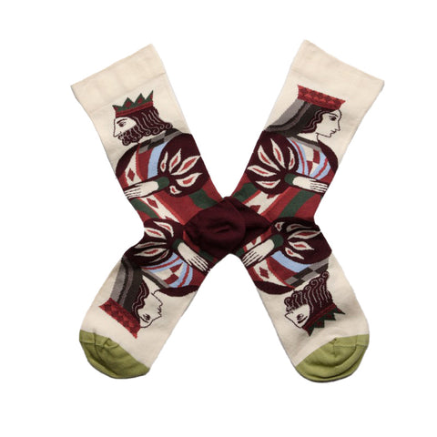A pair of cream socks with green toes featuring a design of a mirrored king and queen on each sock. 