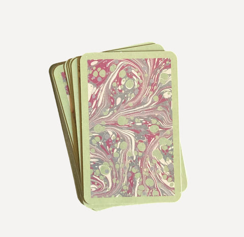 The green and pink marbled back of a deck of cards.