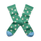 Green socks with white polka dots on a white background