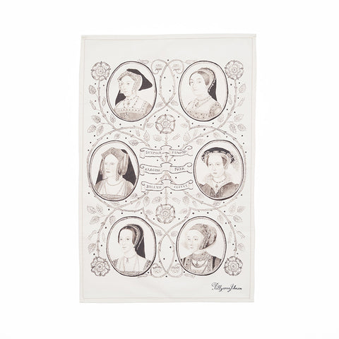 Cream tea towel with black and white portraits of the six wives of Henry VIII, arranged in a family tree motif with vines and roses connecting them.