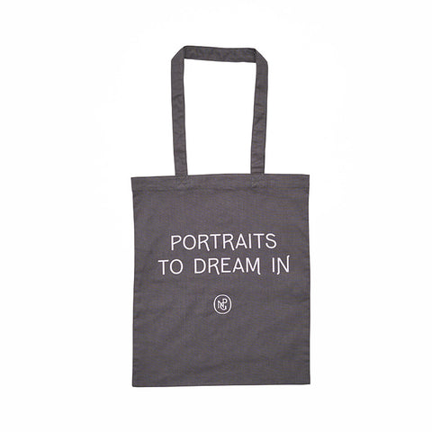Grey tote bag with 'Portraits to Dream in' in purple text. 