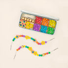 Colourful bead set with a partially completed bracelet on a beige background