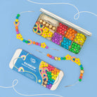 Rainbow beading kit with beads and thread on a blue background