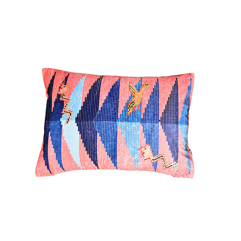 Front of rectangular velvet cushion in a pink and blue geometric pattern with animal shapes. 