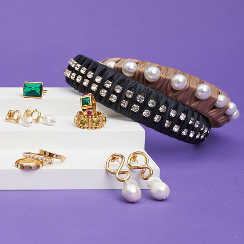 A miniature staircase with a selection of gold rings, earrings and headbands displayed on the steps.