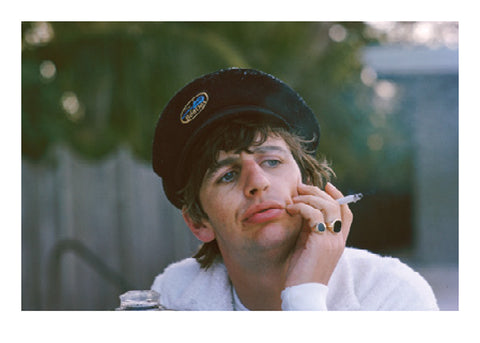 Colour photograph of Ringo starr wearing a hat and smoking a cigarette, taken by Paul McCartney.