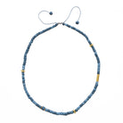 Blue beaded necklace with gold accents on a white background