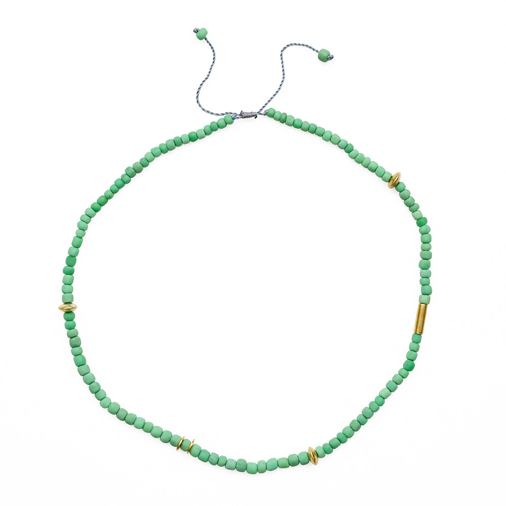 Green beaded necklace with gold accents on a white background