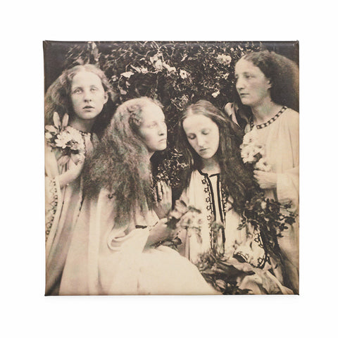Square magnet featuring a photograph in sepia tone of four girls in white dresses holding flowers in a garden. 
