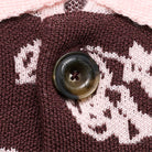 Close-up of a button on a knitted fabric with a floral pattern