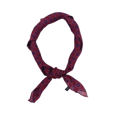 A burgundy geometric bandana tied in a knot. 