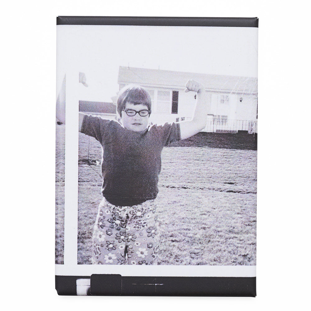Magnet with a black and white photo of a child with arms raised, framed in a black border.
