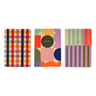 Three colorful notebooks with different patterns on a white background