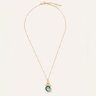 A delicate gold chain necklace with a small oval pendant featuring a light blue-green stone and tiny clear accent stones, displayed on a clean off-white background.